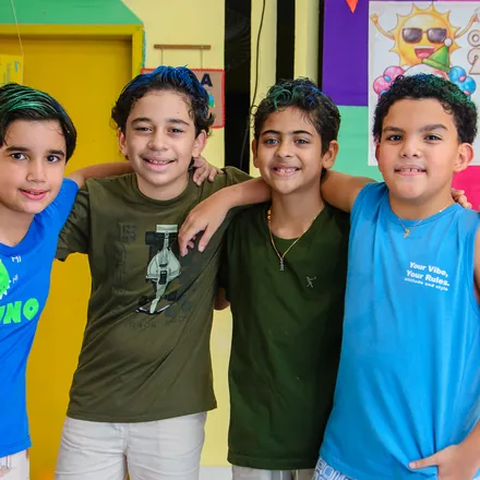 Estudantes do Ensino Fundamental abraçados e sorrindo